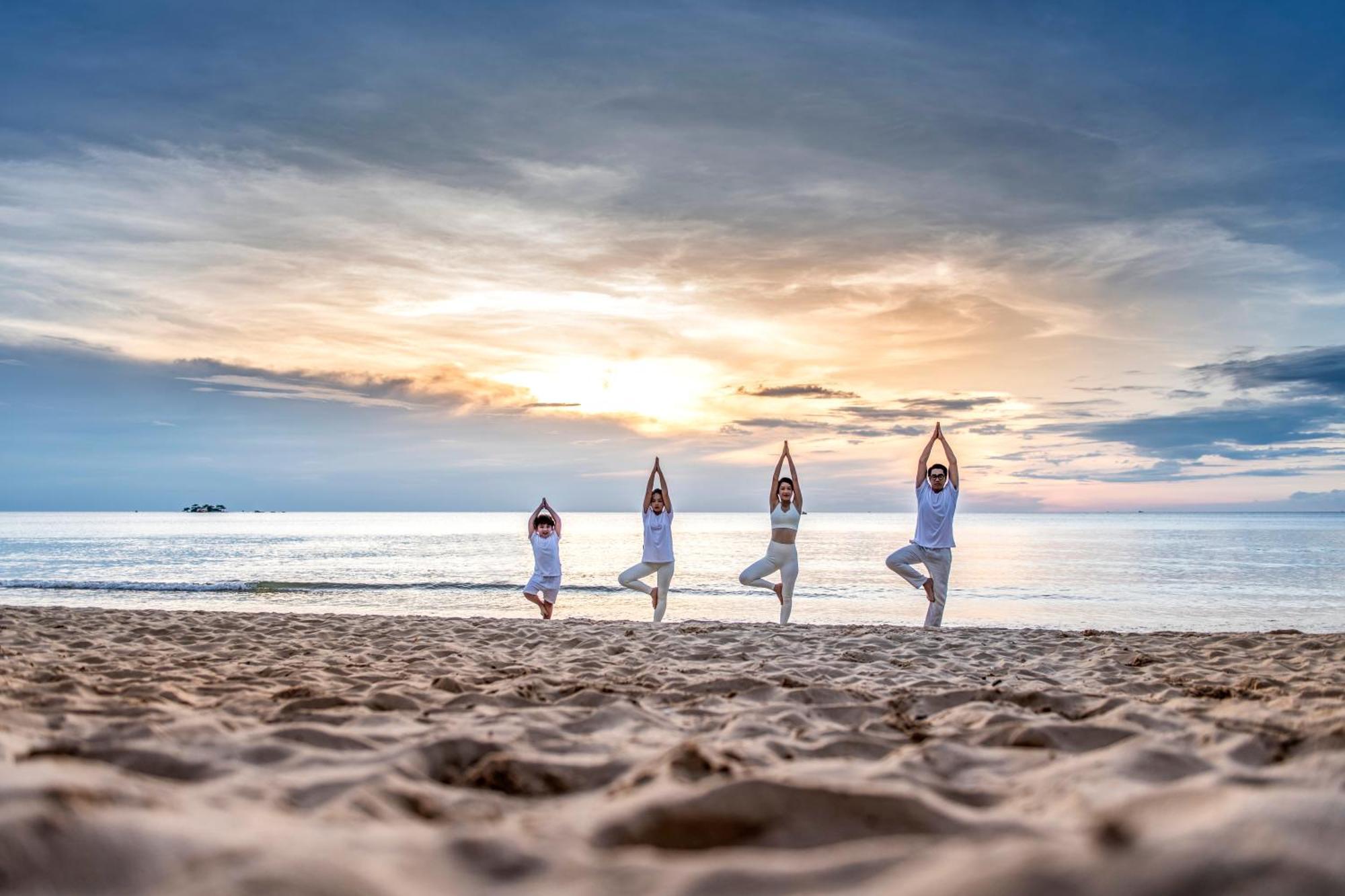 Vinpearl Resort & Spa Phu Quoc Luaran gambar Family practicing yoga on the beach
